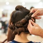 woman in blue shirt holding her hair