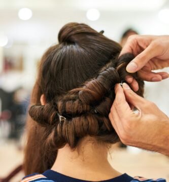 woman in blue shirt holding her hair